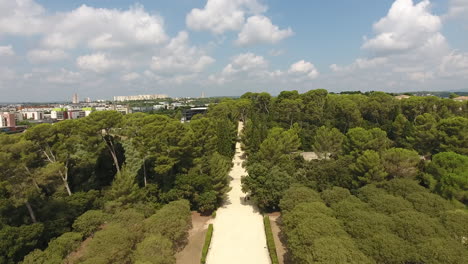 Drone-Volando-Entre-árboles-Hacia-Un-Jardín-Formal-Francés-Domaine-D&#39;o.-Montpelli